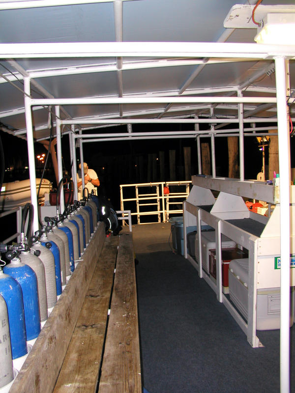 One side of the dive deck with tanks and bench on one side, utility table opposite.