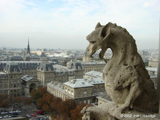 Stone chimera on the railing of the gallery that circles and connects the towers of the facade of Notre-Dame Cathedral.