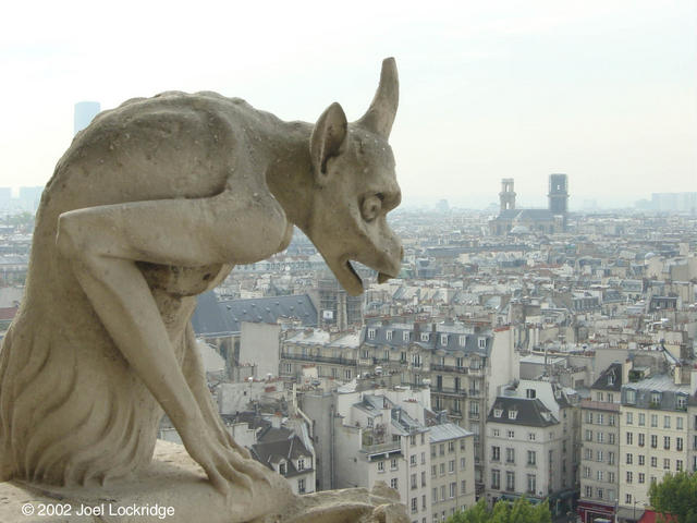 Stone chimera on the railing of the gallery that circles and connects the towers of the facade of Notre-Dame Cathedral.