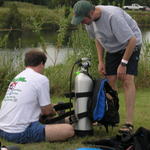 Bruce trying to figure out how to put the tank strps thru the cams on his Zeagle. Andy is lending him a hand. I think it finally