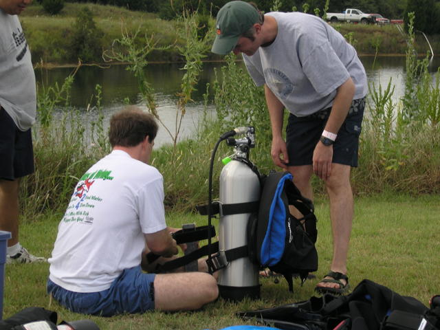 Bruce trying to figure out how to put the tank strps thru the cams on his Zeagle. Andy is lending him a hand. I think it finally